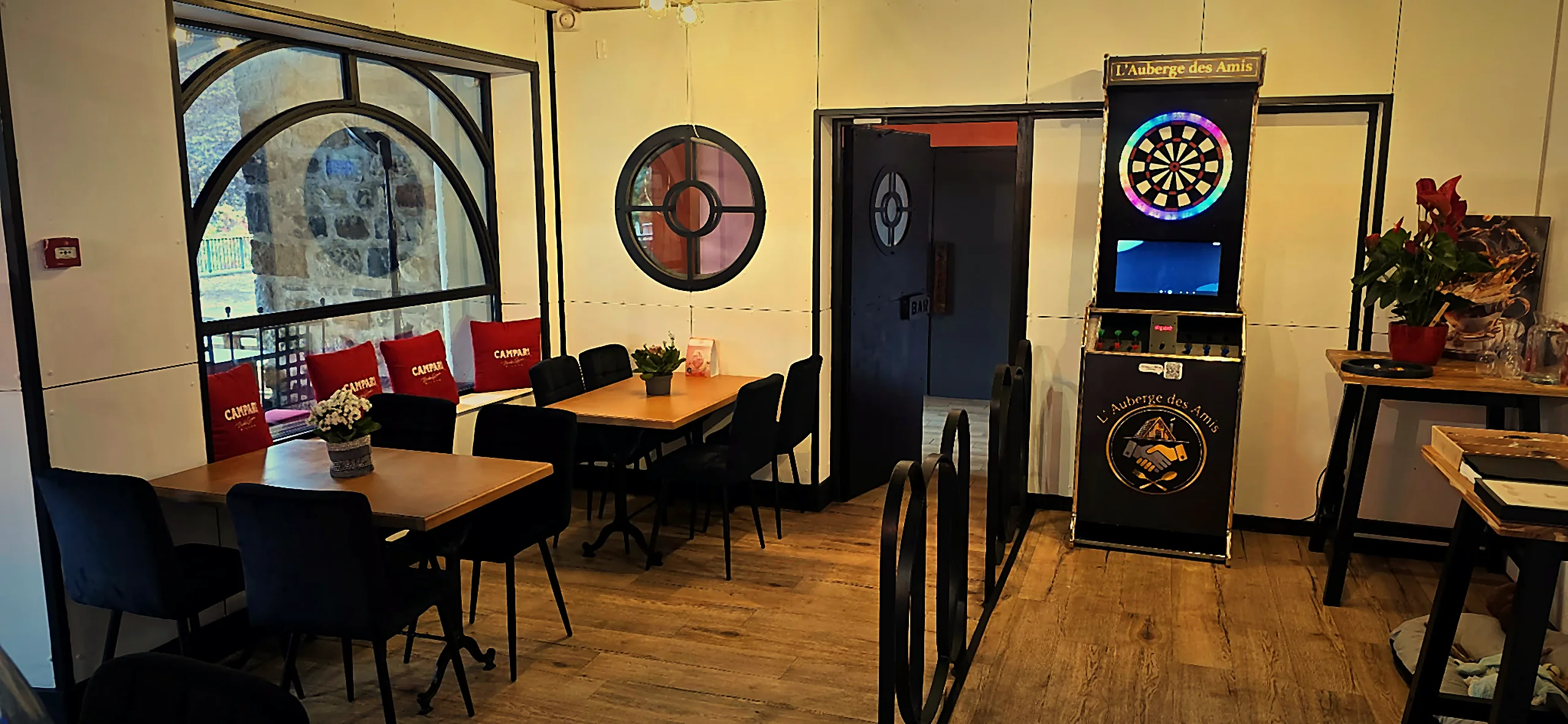 Coin jeux avec fléchettes aux couleurs de l'auberge, fenêtres en arche